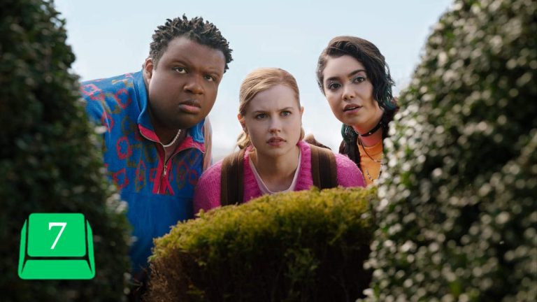 Mean Girls 2024, Cady, Damien, and Janis watch from behind the overgrowth. Review score 7.
